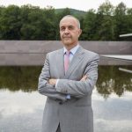 Olivier Meslay standing in front of the reflecting pool at The Clark