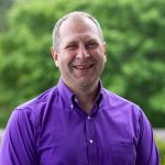 headshot of Todd standing outside wearing a purple shirt